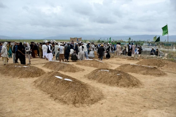 Afghan relatives offer prayers during a burial ceremony for victims of flooding in Baghlan province, May 11, 2024