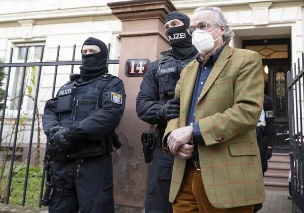 Masked police officers lead Heinrich XIII Prince Reuss, right, to a police vehicle during a raid against so-called 'Reich citizens' in Frankfurt, Germany (files)