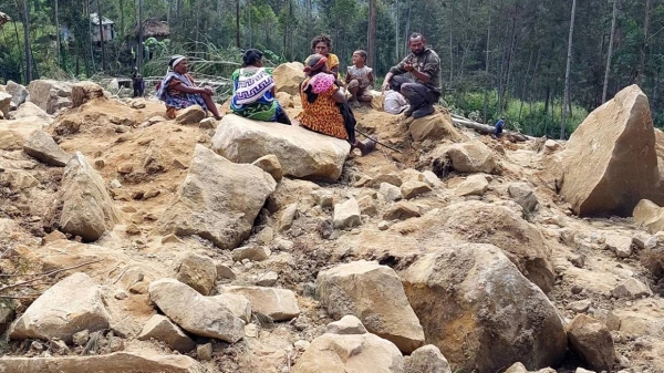 People gather at the site of a landslide in Papua New Guinea's Enga Province