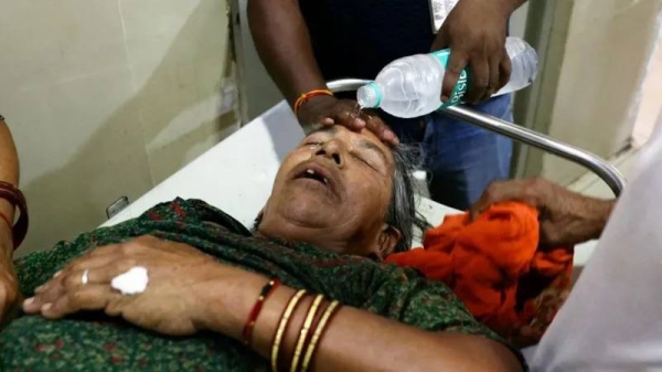 A staff member pours water on the face of a patient suffering from heat stroke in a hospital in Varanasi