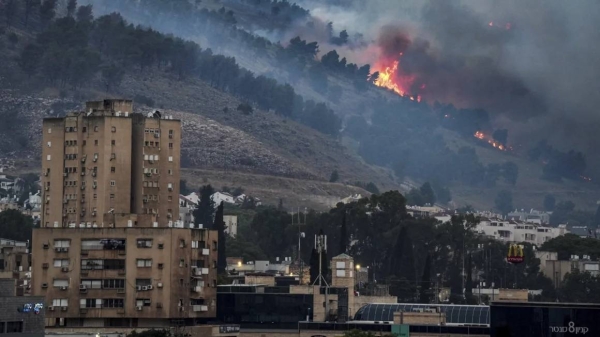 Smoke and fire are seen near Kiryat Shmona, Israel, following what Israeli police said were rocket attacks from southern Lebanon on Monday