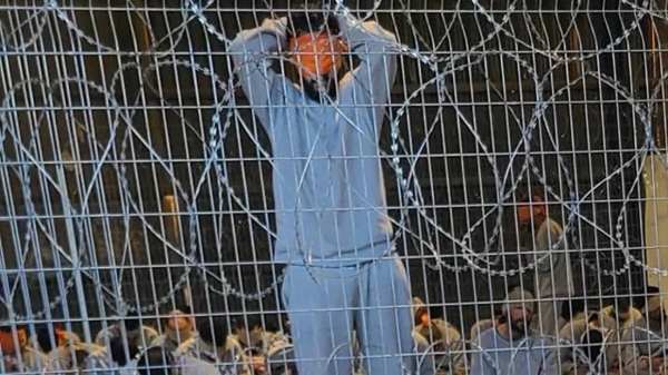 A leaked photograph of an enclosure where detainees in gray tracksuits are seen blindfolded and sitting on paper-thin mattresses