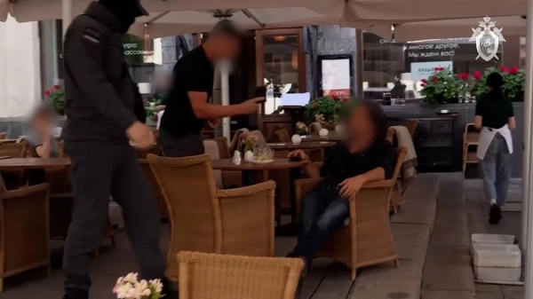 An image taken from a video released by the Russian Investigative Committee shows the man being arrested by security personnel at a cafe in Moscow. The video was blurred by the source