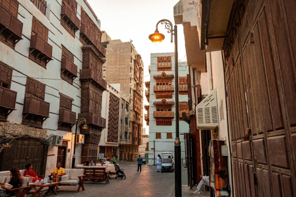 Men and women lounging outside multi-storey buildings in Al Balad. (Supplied)