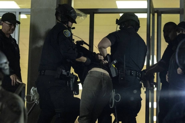 A pro-Palestinian demonstrator is taken into custody Monday outside Dodd Hall at UCLA