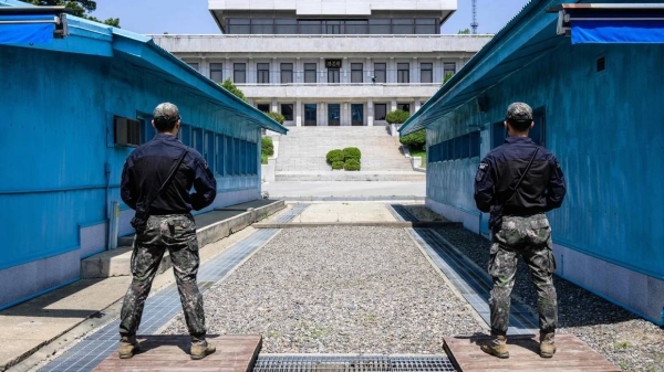 In this photo taken on May 9, 2023, South Korean soldiers stand guard as they face North Korea's Panmon Hall (back) at the truce village of Panmunjom in the Joint Security Area (JSA)