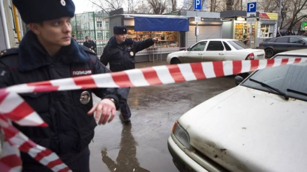 Police set a crime scene tape near a suspicious car, background, in Moscow, Russia, Saturday, Feb. 28, 2015