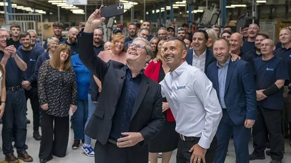 Labour Party leader Sir Keir Starmer takes a selfie alongside staff during a visit to Window Supply Company in Bathgate, West Lothian, Friday June 21, 2024