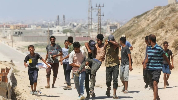 Palestinians heading toward Gaza City after the evacuation warnings carry a man injured in an Israeli attack on July 8, 2024