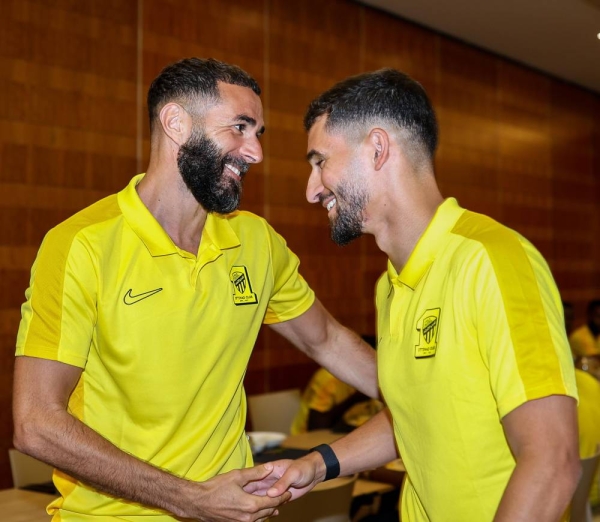 Kareem Benzema welcomes Houssem Aouar at the team's training camp in Alicante, Spain.