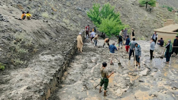 Afghan residents shovel mud following flash floods after heavy rainfall at Pesgaran village in Dara district, Panjshir province, Afghanistan on July 15, 2024