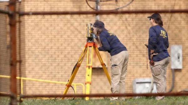 Members of the FBI Evidence Response Team work near the building where the gunman was shot dead