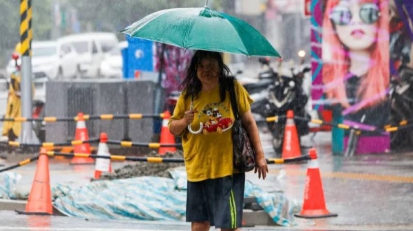 A woman walks in heavy rain in New Taipei after local governments across the island suspended work and classes to brace for Typhoon Gaemi on Wednesday