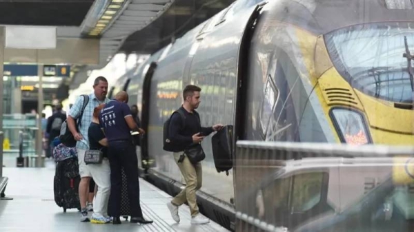 Passengers board a train at the Eurostar terminal at St Pancras station in central London. French rail officials say several lines have been hit by 'malicious acts' which have heavily disrupted services ahead of the Olympics