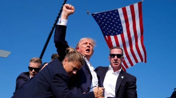 Former President Donald Trump is surrounded by Secret Service agents after an assassination attempt at a campaign rally in Butler, Pennsylvania, on July 13, 2024