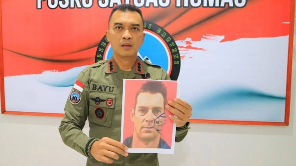 Bayu Suseno, spokesperson for the Cartenz 2024 Peace Task Force, holds a portrait of pilot Glen Malcolm Conning during a press conference in Timika, Indonesia, on Aug. 5, 2024