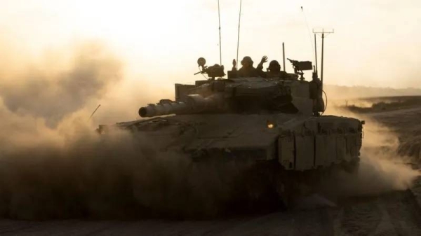 Israeli soldiers in a tank driving along the border with the Gaza Strip in southern Israel