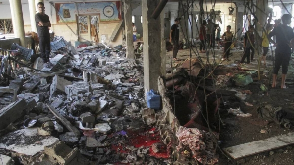 Palestinians inspect the damage after an Israeli strike on a school in Gaza City on Saturday