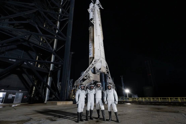 The Polaris Dawn crew poses in front of the Falcon 9 rocket and Crew Dragon spacecraft at launchpad 39A at Kennedy Space Center