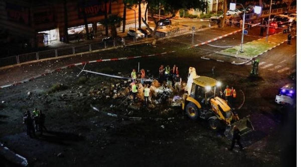 Israeli rescue teams inspect the site of a rocket attack in Haifa, northern Israel on Monday.