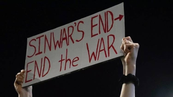 A demonstrator holds a sign about the killing of Hamas leader Yahya Sinwar during a protest calling for a cease-fire deal, Thursday, Oct. 17, 2024, in Tel Aviv.