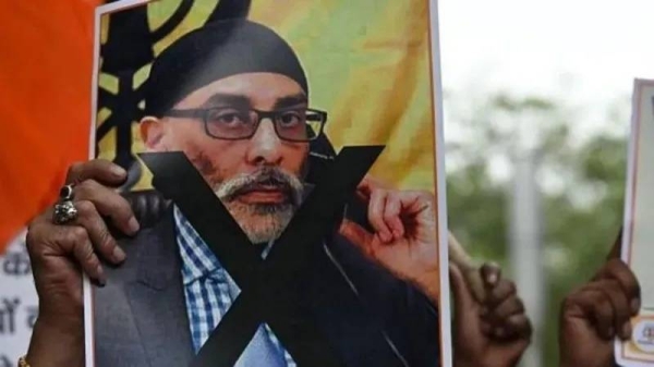 A man holding an image of Sikh separatist leader Gurpatwant Singh Pannun