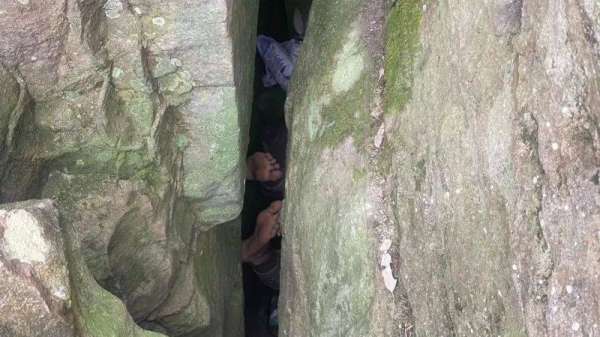 Woman reaching for phone gets stuck upside down in boulders