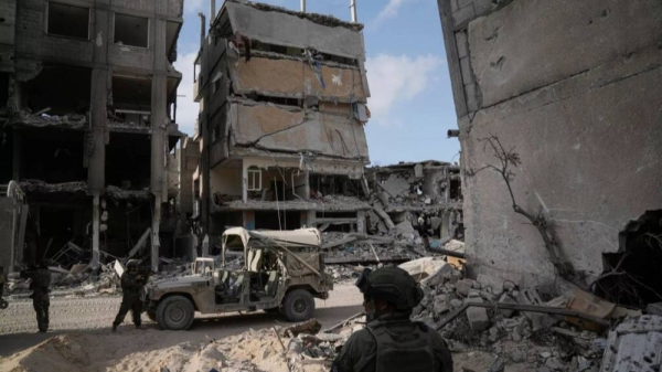 Israeli soldiers take up position next to destroyed buildings following Israeli strikes during a ground operation in the Gaza Strip on Friday, Sept. 13, 2024