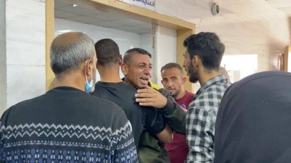 A man is comforted at the Gaza Strip's Kamal Adwan Hospital, which has been described as 'completely overwhelmed' by Medecins Sans Frontieres