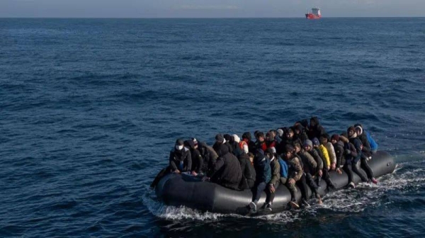 An overloaded dinghy carries migrants across the Channel (file photo)