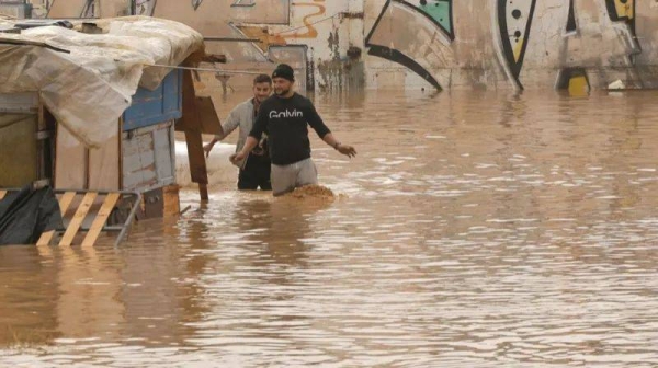 People walking through a flooded highway in the city of Valencia