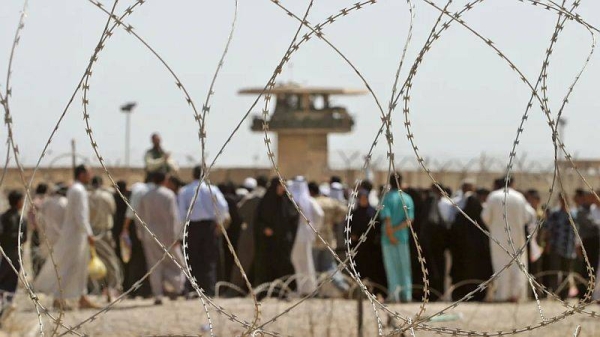 Iraqis line up outside Abu Ghraib prison near Baghdad, while they wait to get information about their relatives held inside, on May 16, 2004