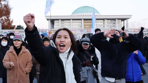 Protesters shouting and gesturing outside South Korea's National Assembly