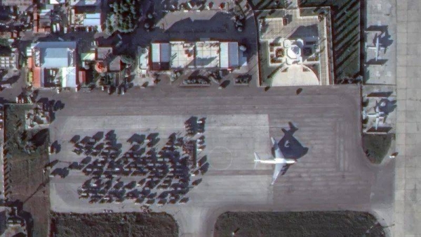 Dozens of military vehicles at the airfield near a Russian-made Ilyushin Il-76 military transport plane on 15 December