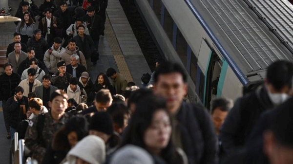 Commuters disembark from a train at a train station in Seoul on December 6, 2024