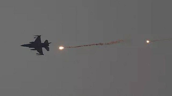 An Israeli fighter jet releases flares as it flies over the Gaza Strip, as seen from southern Israel