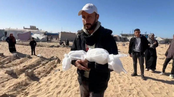 Sila's father carries her tiny body to be buried