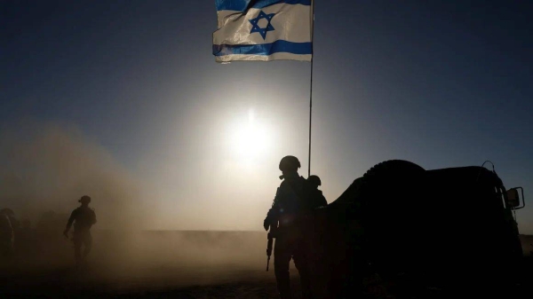 Soldiers with the Israel Defense Forces (IDF) stand near a military vehicle on March 4, 2024 in southern Israel near the border with Gaza