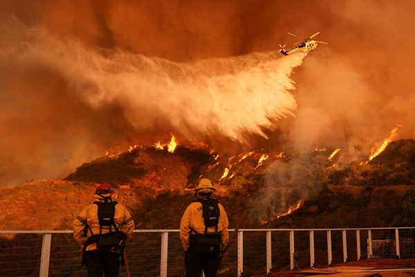 Firefighters watch as water is dropped on the Palisades Fire in Mandeville Canyon, in Los Angeles, on January 11.