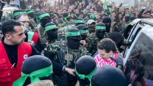 Doron Steinbrecher, one of the Israeli hostages released on Sunday, is handed over by Hamas fighters to a Red Cross official in Gaza City