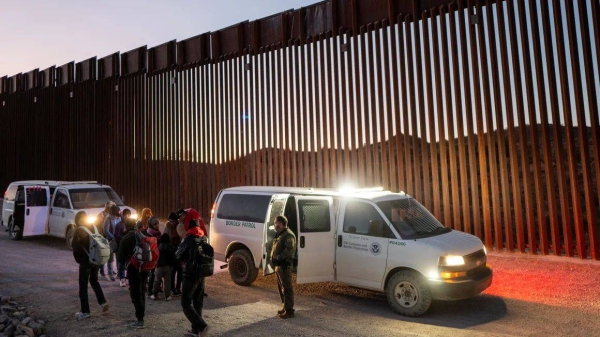 Migrants turn themselves in to US Customs and Border Patrol officers after crossing over a section of border wall into the US on January 5, 2025 in Ruby, Arizona