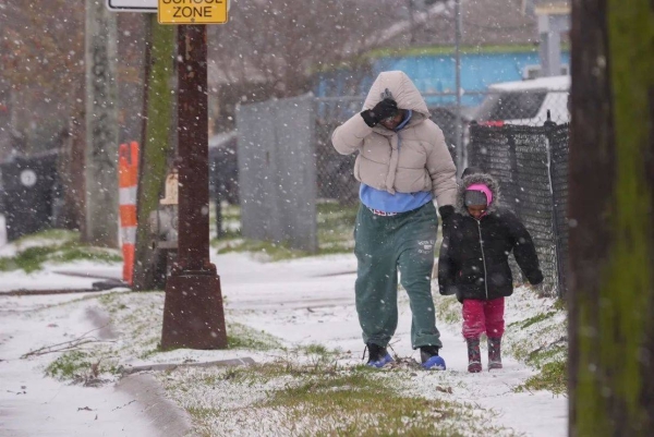 Lesley Martin and her 4-year-old daughter Layla Richardson walk on a snow covered street in New Orleans Tuesday morning