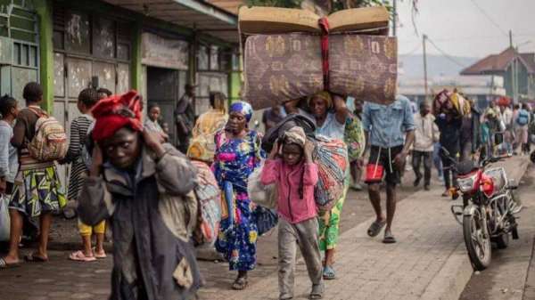 Residents carry their belongings as they flee from Kibati, where fighting has intensified, toward the city of Goma on January 26, 2025