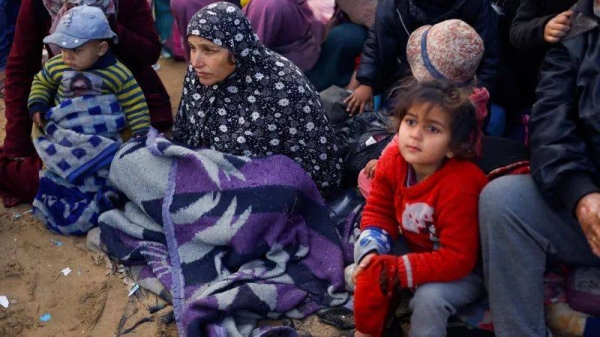 Palestinians wait to be allowed to return to their homes in northern Gaza after they were displaced to the south at Israel's order during the war