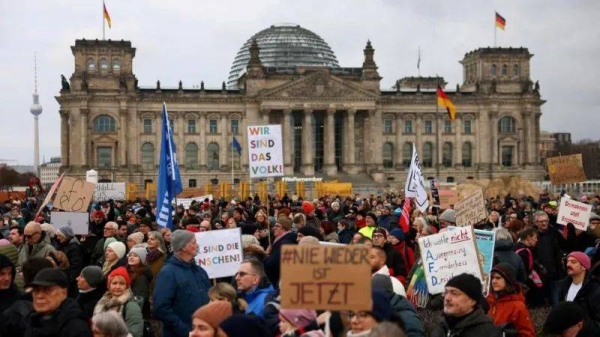 Dozens of protesters gathered outside Germany's parliament holding up signs