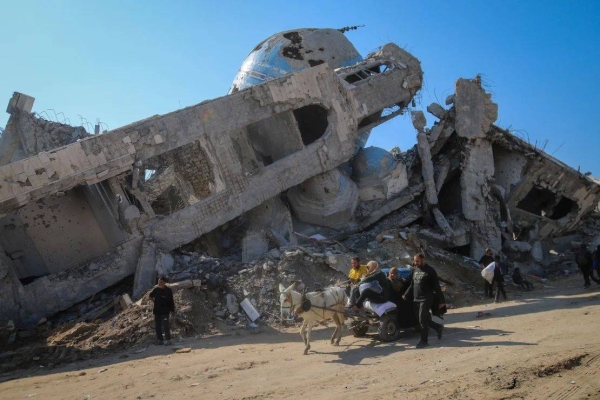 A family rides in a horse-drawn cart past a destroyed mosque in Beit Lahia, Gaza, on January 29