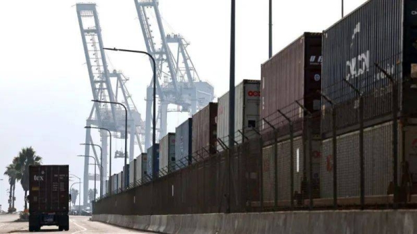 A truck drives past shipping containers stacked on rail cars at the Port of Long Beach on December 4, 2024 in Long Beach, California. 
