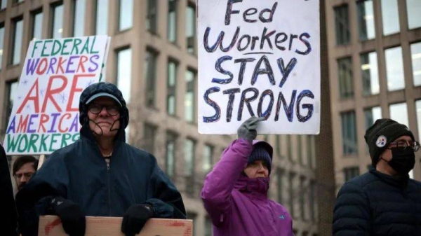 People protest with signs in support for US government workers