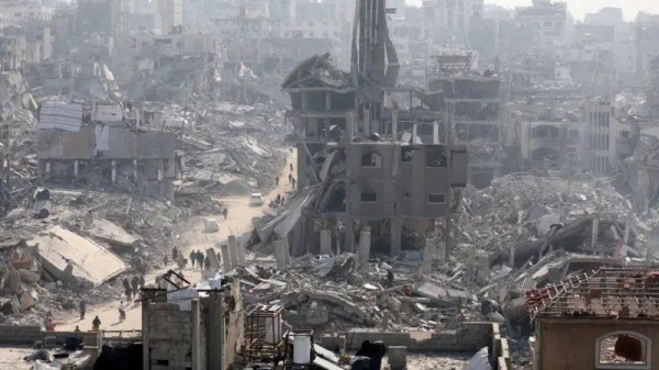 People walk past the rubble of destroyed buildings, inJabalia, in the northern Gaza Strip, on 30 January 2025