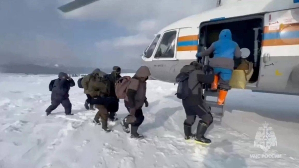 Fishermen stranded on an ice floe in the Sea of Okhotsk board a helicopter during a rescue operation in the Sakhalin region, Russia, February 12, in this still image taken from video